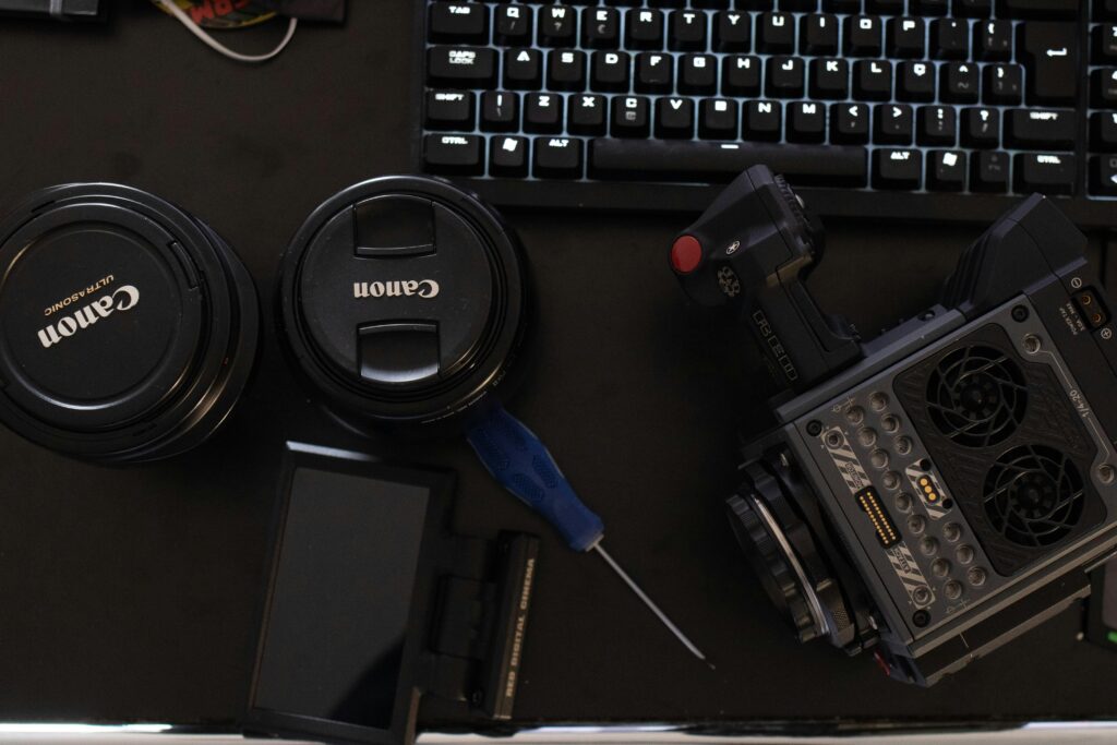 Close-up of camera gear and keyboard on a work desk for media production.