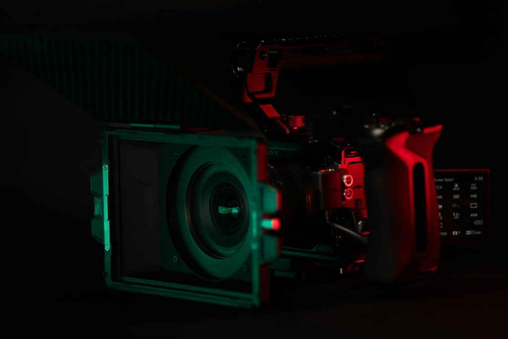 Close-up of a cinema camera rig with striking neon lighting, perfect for videography setups.