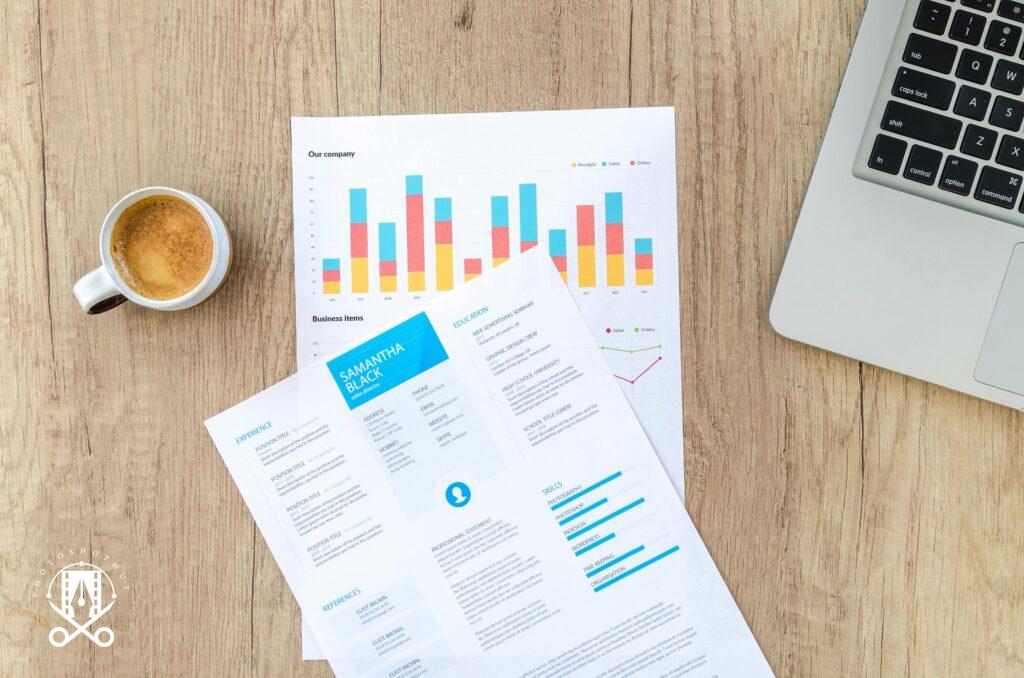 Wooden desk with documents, laptop, and coffee cup creating a modern office atmosphere.